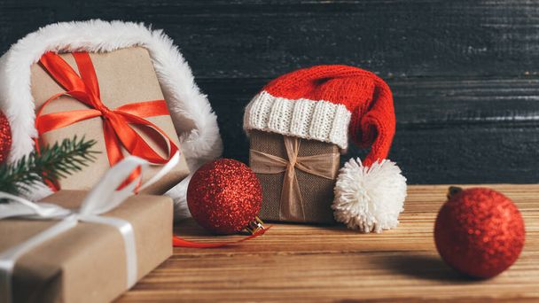 Cajas de regalos de Navidad sobre mesa de madera en papel Kraft y decoradas con cintas - Foto, Imagen