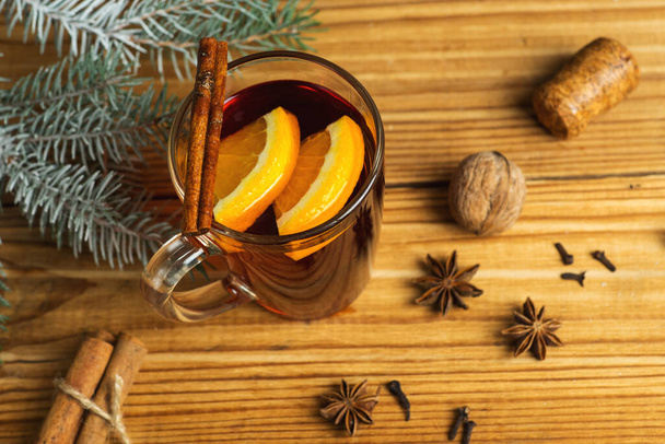 Őszi és téli szezonális forralt bor fából készült asztalon fűszerekkel - Fotó, kép