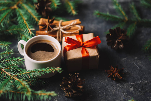 Fundo de Natal com galhos de árvore, café e caixa de presente na mesa de pedra escura - Foto, Imagem