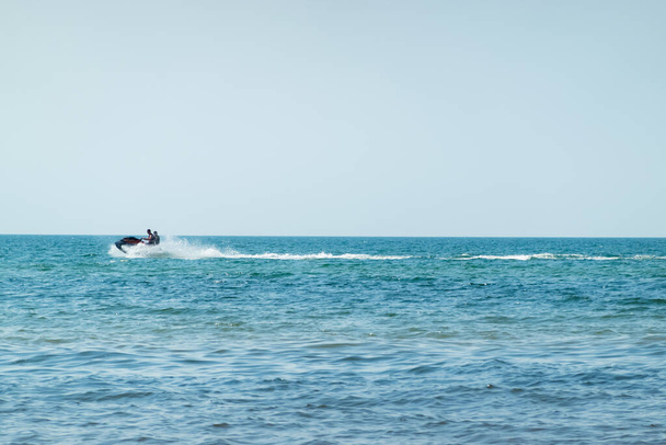 Le persone che godono di moto d'acqua in un mare blu in una giornata di sole. Attività acquatiche per vacanze tropicali. - Foto, immagini