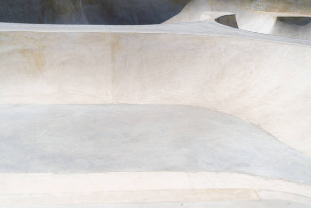 Parque público de patinaje de hormigón en un día soleado. Rampas de cemento para skate y bmx. Deporte extremo - Foto, imagen