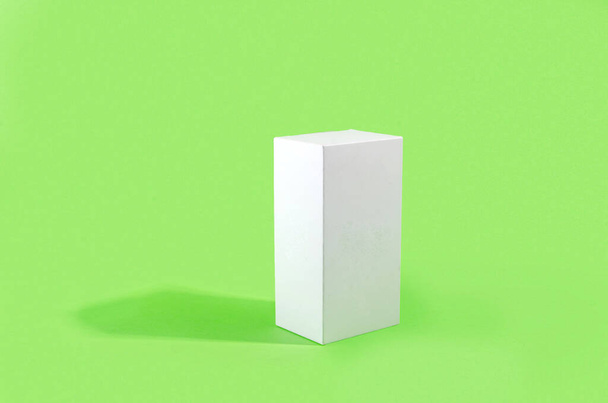 White geometric figure, a rectangular with shadows on a light green background. Abstract minimal scene with empty place for a signature, mock-up - Foto, imagen