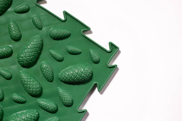Eine grüne orthopädische Matte mit dem Design von Zapfen, um Plattfüße zu verhindern. - Foto, Bild