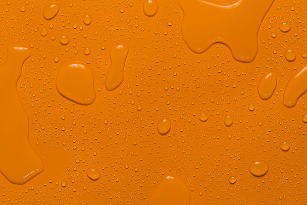 közeli vízcsepp narancs háttér - Fotó, kép