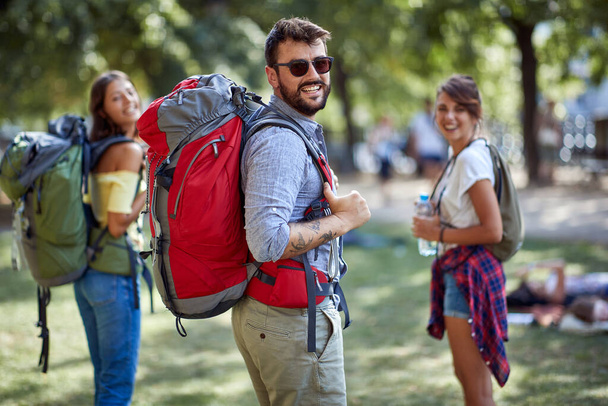 Group of smiling  friends backpackers walking and traveling  and enjoying  together. - 写真・画像
