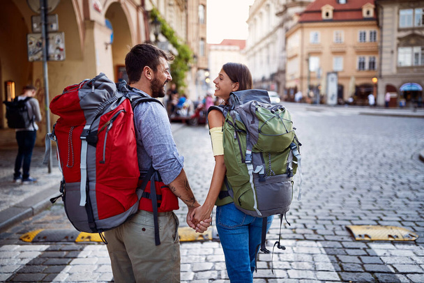 Walking at European street at vacation.Smiling Man and woman with backpack in love traveling together. - Foto, immagini