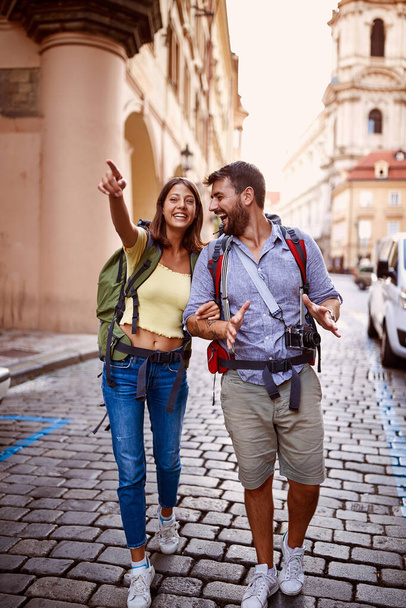 Smiling man and woman walking at European street at vacation. - Fotografie, Obrázek