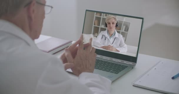 online raad van artsen via internet, man en vrouw communiceren en discussiëren via webcamera van laptop - Video