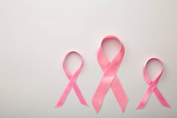 Pink satin breast cancer awareness ribbons on grey background - 写真・画像