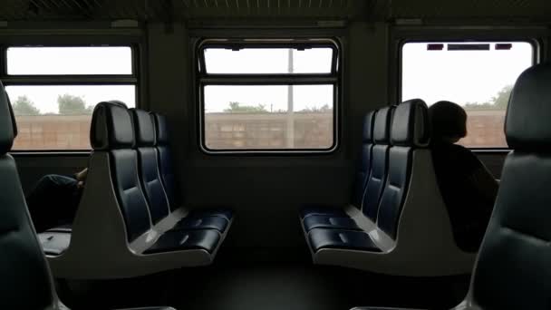 Interior de un tren de pasajeros con asientos vacíos por la tarde - Imágenes, Vídeo