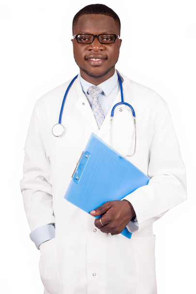 Портрет профессионального врача со счастливым выражением лица, стоящего в студии и держащего блокнот - Фото, изображение