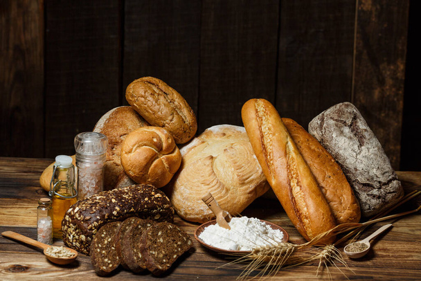 Fresh assorted loaves of gluten-free bread on wooden table - Fotoğraf, Görsel