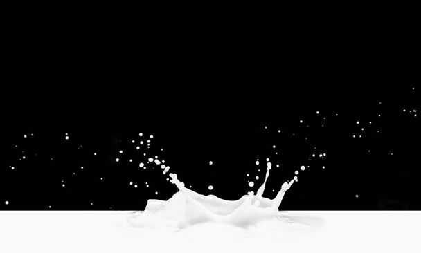 Pouring milk splash isolated on black background - Photo, Image