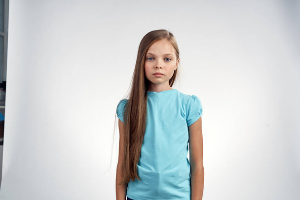 cute girl blue dresses cropped view light background emotions childhood fun - 写真・画像