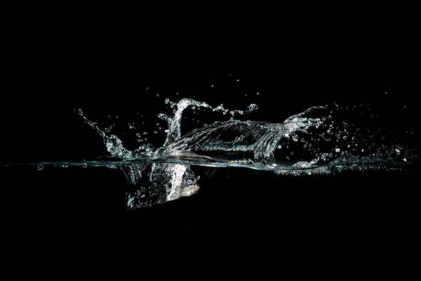 close up of water waves splash and bubbles isolated on black background. - Photo, Image