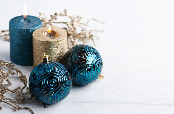 Kék golyók, arany illatú gyertyák és karácsonyi játékok fából készült rusztikus háttérrel. Téli készlet fénymásolási hellyel - Fotó, kép