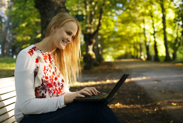 mujer joven usando su portátil en el parque
 - Foto, imagen