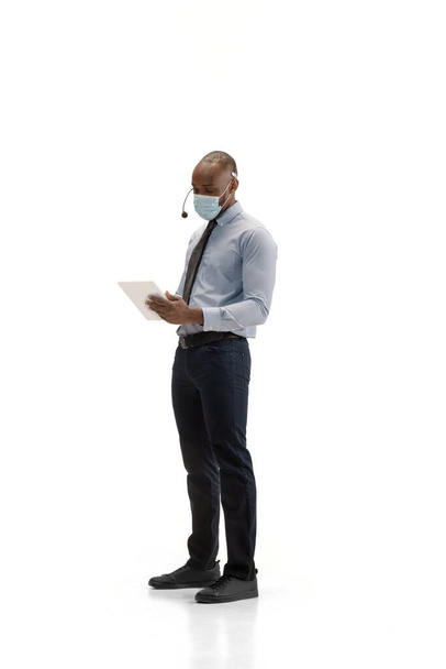 Young african-american call center consultant with headset isolated on white studio background - Foto, Bild