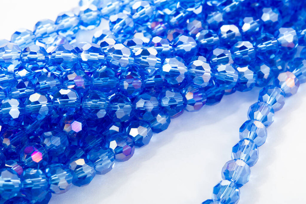 Hermosas perlas de cristal brillante azul Isoalted Crystal sobre fondo blanco. Utilizar para joyería de cuentas de bricolaje. Espacio para texto - Foto, imagen