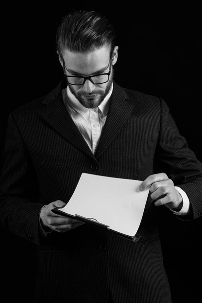 hombre de negocios reflexivo en traje sobre fondo negro, espacio de copia - Foto, Imagen