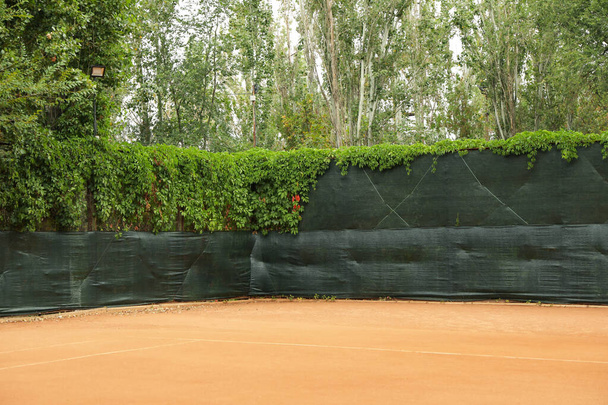 Πηλός γήπεδο τένις με πράσινο φράχτη, χώρος για κείμενο - Φωτογραφία, εικόνα