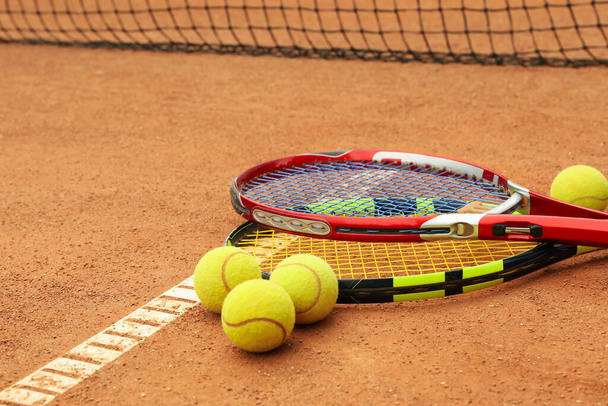 Tennis racquets with tennis balls on clay court - Fotoğraf, Görsel