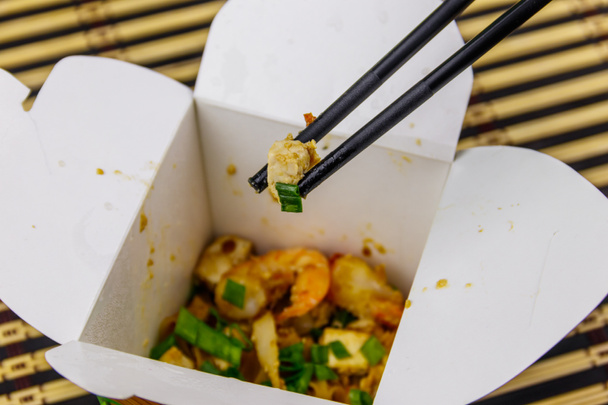 Stir-fried rice noodles Pad Thai with prawns and tofu in open cardboard box takeaway. Thai cuisine,  Food delivery - Фото, зображення