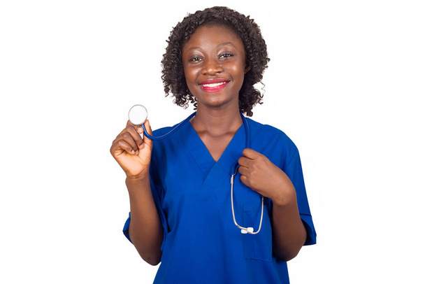 smiling nurse woman or doctor standing in studio, holding stethoscope and listening to lung beat isolated on white background - Photo, Image