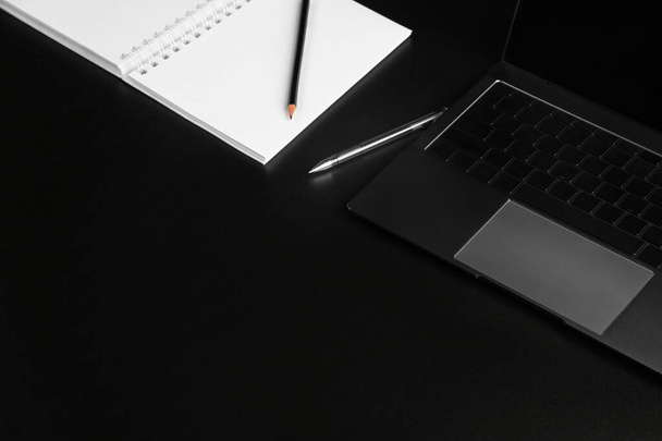 επαγγελματική διάταξη, πλήκτρα πληκτρολογίου και θραύσματα laptop σε μαύρο και ασημί, σημειωματάριο με λευκό χαρτί, στυλό και μολύβι, φόντο - Φωτογραφία, εικόνα