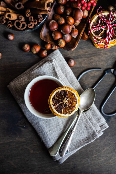 Milled or spiced wine or  Gluehwein with oranges, anise star, cinnamon and berries on rustic wooden table with copy space - Fotoğraf, Görsel