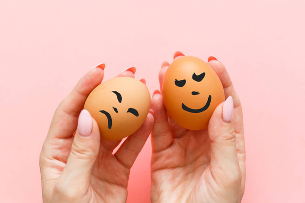 Two eggs In hand holding on a pink background - 写真・画像