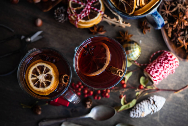 Milled or spiced wine or  Gluehwein with oranges, anise star, cinnamon and berries on rustic wooden table with copy space - Valokuva, kuva