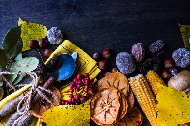 Día de Acción de Gracias o concepto de cosecha otoñal con marco con frutos secos, bayas, verduras y frutas sobre fondo de madera oscura con espacio para copiar - Foto, imagen