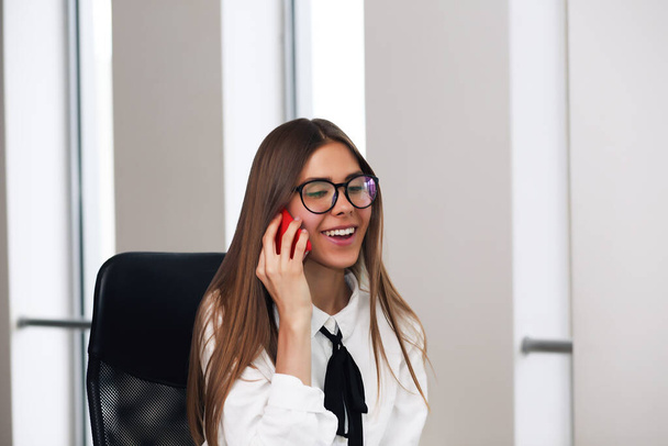 young business lady chats on the phone in the office while working - Φωτογραφία, εικόνα