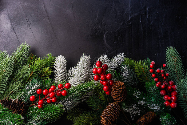 Concepto de marco de Navidad con ramas de árbol de Navidad y decoración de vacaciones rojas sobre fondo de piedra gris con espacio para copiar - Foto, imagen