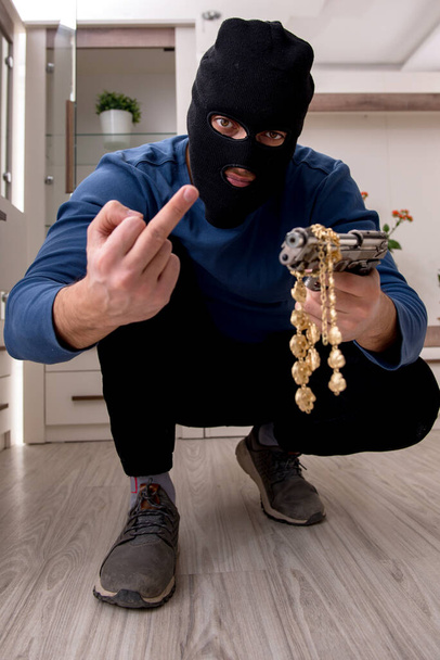 Άντρας ληστής κλέβει πολύτιμα πράγματα από το σπίτι - Φωτογραφία, εικόνα