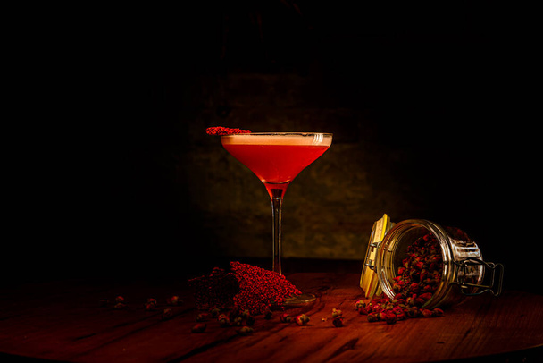 Ein roter alkoholischer Cocktail mit Schaum im Glas steht auf der Theke - Foto, Bild