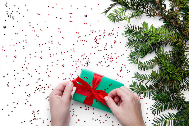 Hands hold Christmas gift with red ribbon  - Photo, Image