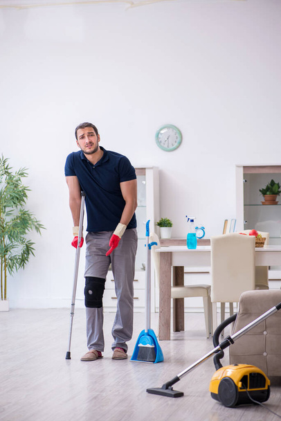 Fiatal lábsérült vállalkozó takarítja a házat - Fotó, kép