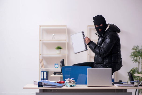 Jovem assaltante masculino no escritório
 - Foto, Imagem