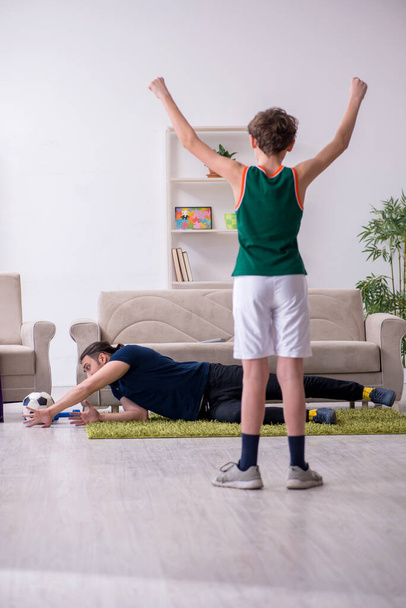 Father and son doing sport exercises indoors - Фото, изображение
