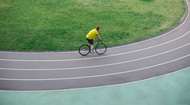 A man rides a bicycle on a track stadium - Фото, зображення