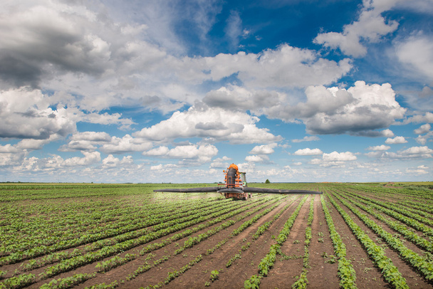 Трактор, распыляющий поле
 - Фото, изображение