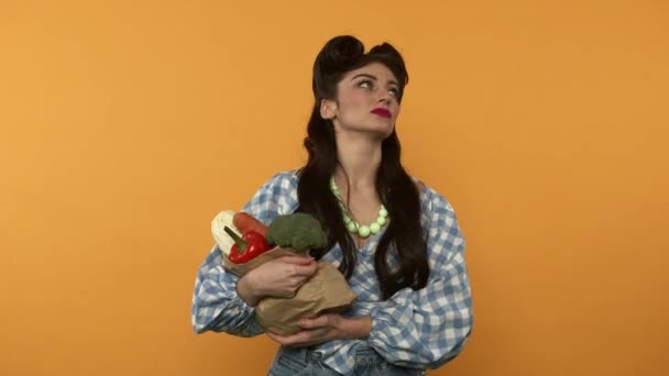 Insatisfeito pin up mulher segurando saco de papel com comida vegetariana - Filmagem, Vídeo