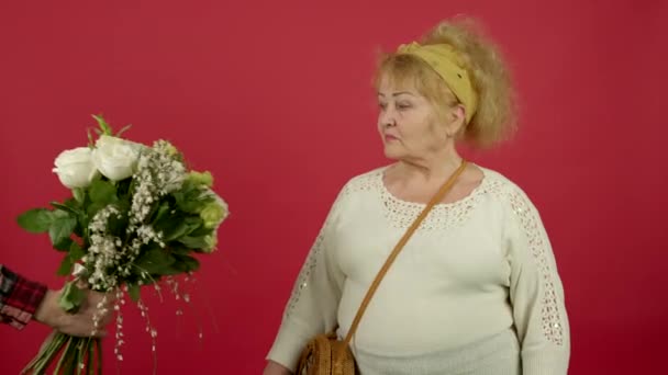 Sobrepeso mulher sênior com bolsa recusando flores - Filmagem, Vídeo