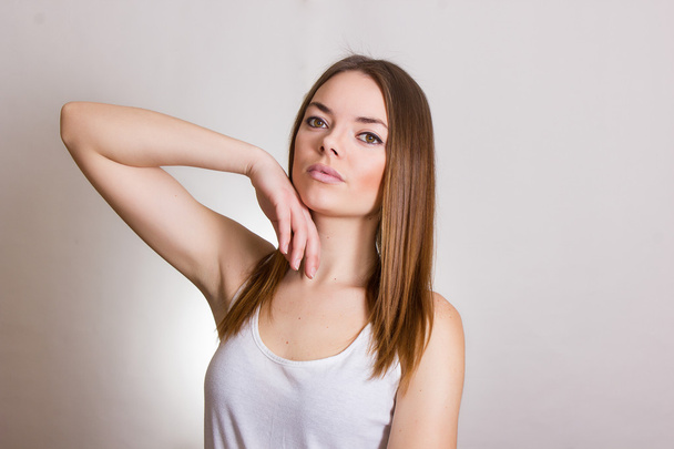 Portrait of a beautiful young woman in a white T-shirt with natural make-up and straight brown hair - Foto, immagini