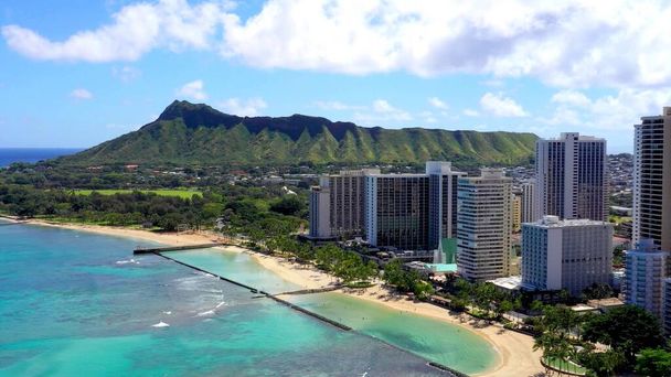 A photo of the buildings of Hawaii on the shore with mountains - Foto, afbeelding