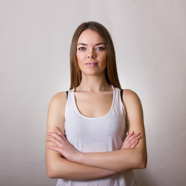 Portrait of a beautiful young woman in a white T-shirt with natural make-up and straight brown hair - Foto, Imagem