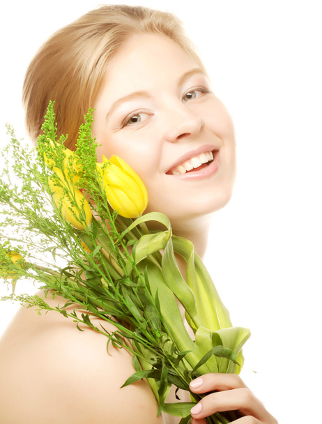 Young smiling woman with yellow tulips - Foto, afbeelding