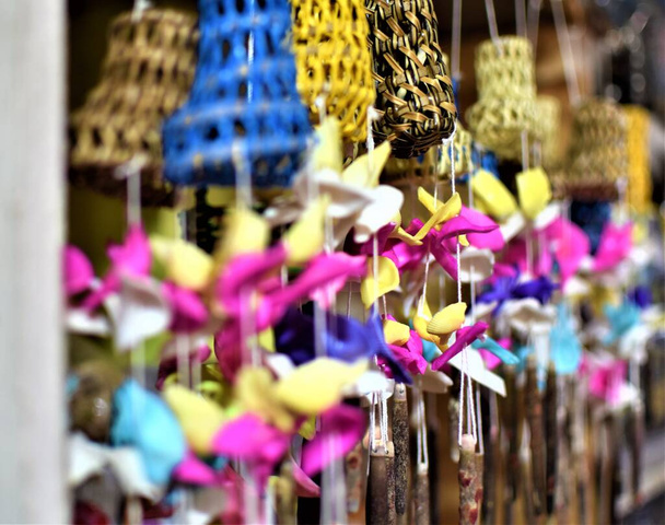 Tradicional colorido ratán y caracol de mar campanas de viento cuelgan en una tienda de recuerdos isla - Foto, imagen